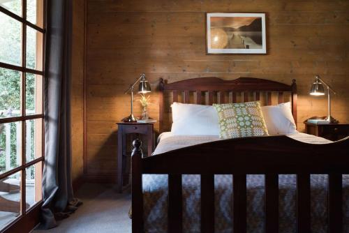 a bedroom with a bed with a wooden wall at All Views in Daylesford