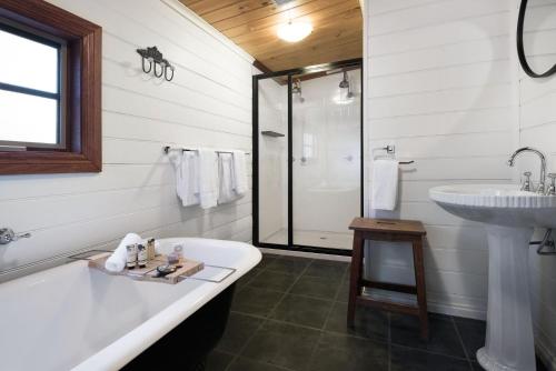 a white bathroom with a tub and a sink at All Views in Daylesford