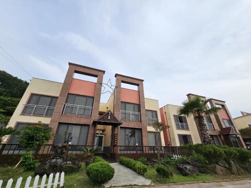 a building with a fence in front of it at Red Castle Pension in Jeju