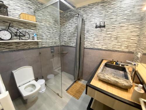 uma casa de banho com um WC, um chuveiro e um lavatório. em Appartement LOUIS XIV avec HAMMAM SAUNA JACCUZI PRIVATISÉ TOTALEMENT GRATUIT SANS SUPPLÉMENT ! em Al Hoceïma
