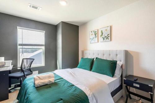 a bedroom with a bed with green pillows and a desk at Modern Retreat near Hartsfield-Jackson Airport in Atlanta