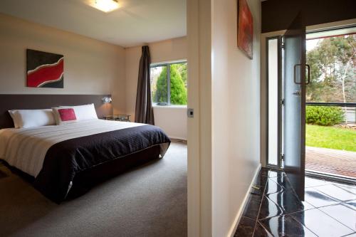 a bedroom with a bed and a sliding glass door at Amici in Daylesford