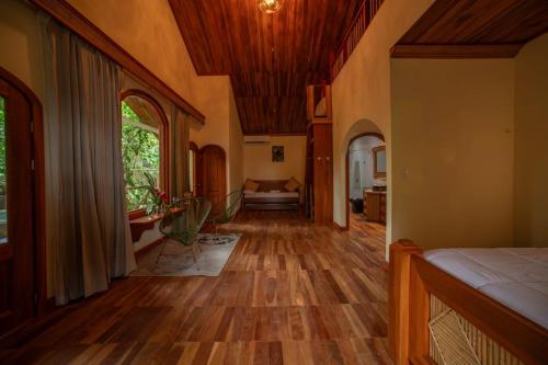 a hallway of a home with wooden floors and a ceiling at Arenal ginger home in Fortuna