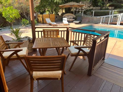 a patio with a table and chairs next to a pool at Villa La Reforma - Newly Designed 4BR HOUSE & POOL in Los Angeles by Topanga in Los Angeles