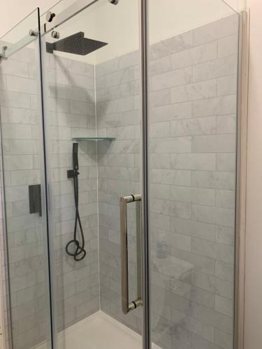 a shower with a glass door in a bathroom at Q Estate Pool cottage in Westport