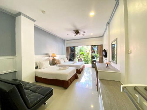 a hotel room with two beds and a bathtub at Garden Home Kata in Kata Beach
