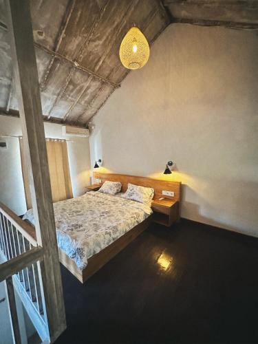 - une chambre avec un lit et un éclairage dans l'établissement Ocean Loft, à Dalung