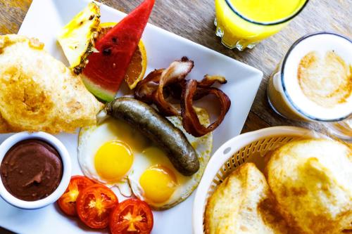 a plate of breakfast food with eggs bacon tomatoes and toast at Coconut Row Boutique Hotel in Hopkins