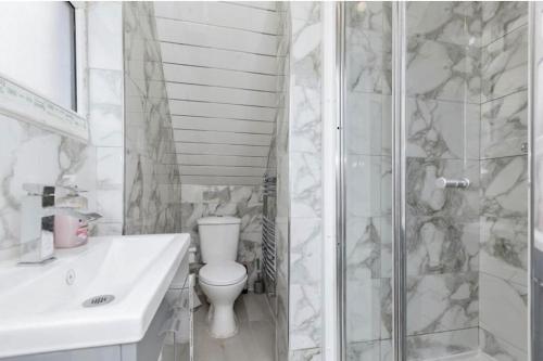 a white bathroom with a toilet and a shower at 3 Bedroom House in Loughborough in Loughborough