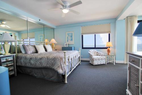 a bedroom with a bed and a chair and a window at Broadmoor 304 in Orange Beach