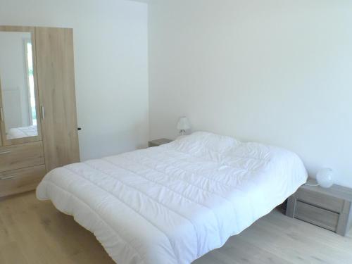 a white bed in a white bedroom with a window at Appartement Samoëns, 2 pièces, 4 personnes - FR-1-629-128 in Samoëns