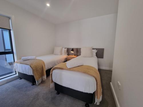a bedroom with two beds with blankets on them at Alpine Junction Townhouse Apartments, Lodge & Hotel in Wanaka