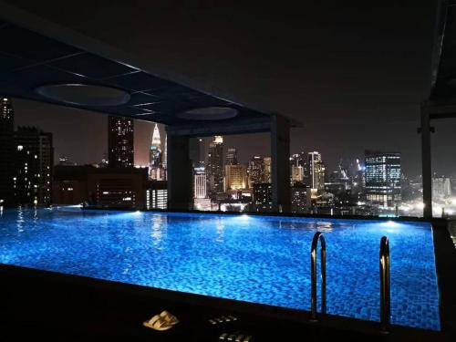 a swimming pool with a city skyline at night at D Majestic Hosted By TCL Home 4141 in Kuala Lumpur