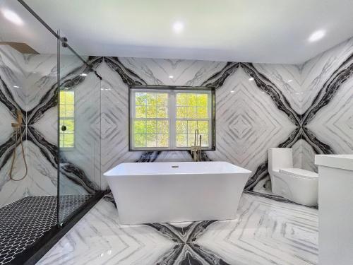 Glen Cove的住宿－Estate Getaway，白色的浴室设有浴缸和淋浴。