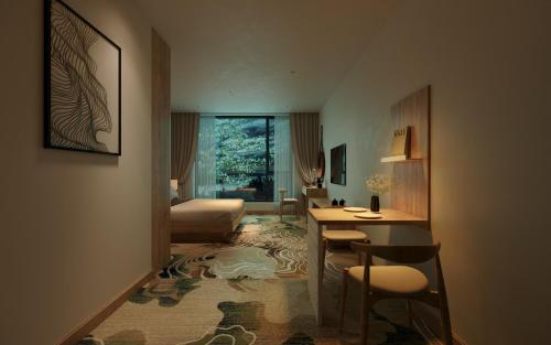 ein Hotelzimmer mit einem Bett, einem Tisch und Stühlen in der Unterkunft Fukurai Boutique Apartments Ha Noi in Hanoi