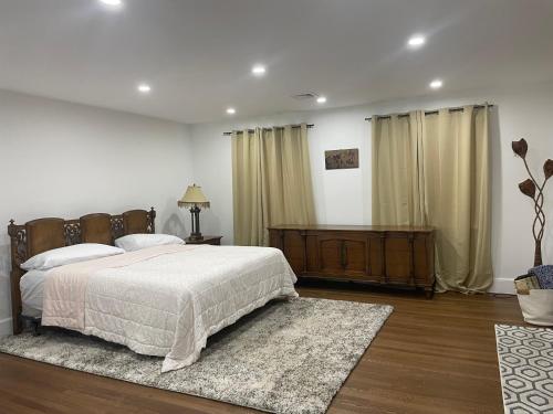 - une chambre avec un grand lit, un tapis et des rideaux dans l'établissement Estate Getaway, à Glen Cove