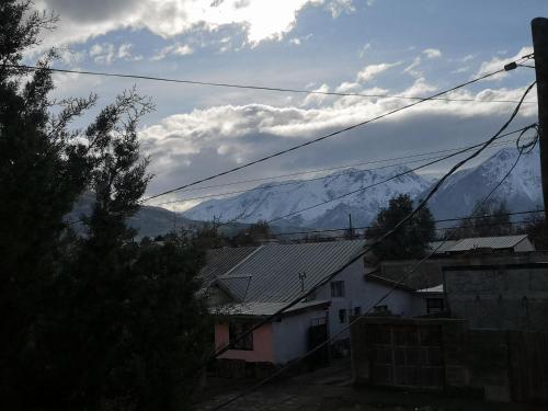 a view of snow capped mountains from a village at Departamento amplio y luminoso in Esquel