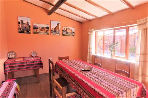 Un comedor con una mesa y una ventana. en Casa Amaru Raqchi, en Anansaya