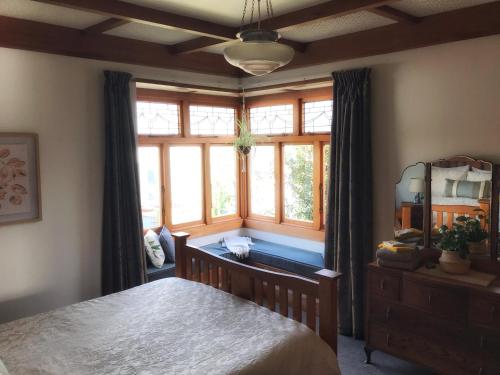 a bedroom with a bed and a large window at 1920s Stay in Whanganui in Whanganui