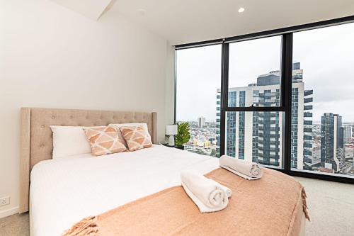 Un dormitorio con una cama grande y una ventana grande. en Fantastic Urban Oasis, en Melbourne