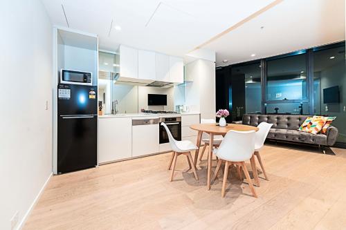 Una cocina y una sala de estar con mesa y sillas. en Fantastic Urban Oasis, en Melbourne