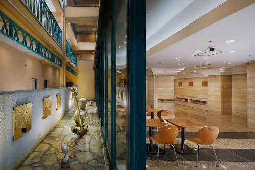 a lobby with a table and chairs in a building at Hotel Villa Fontaine Tokyo-Nihombashi Hakozaki in Tokyo