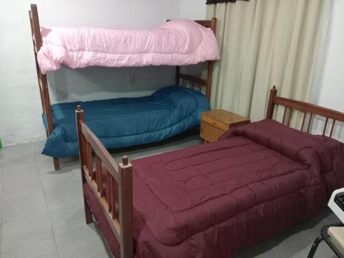 a bedroom with two bunk beds with purple sheets at Alojamiento Mana in Malargüe