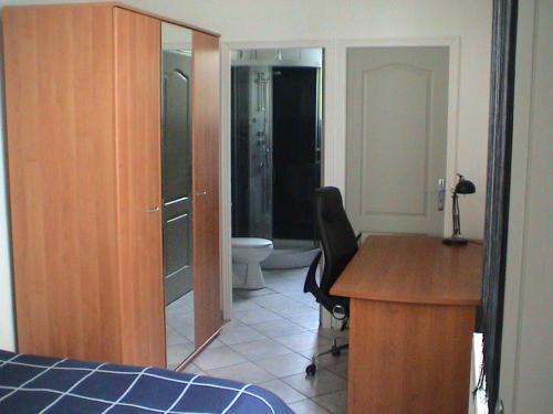 a bedroom with a desk and a bathroom with a toilet at HOMESTAY LILLE in Lille