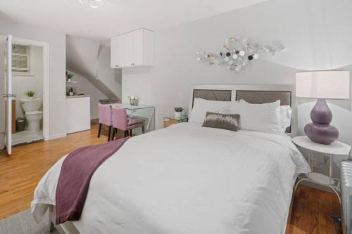 a white bedroom with a large bed and a dining room at Studio Haven in Times Square & Nearby Restaurants in New York