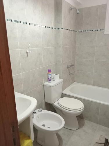 uma casa de banho com um WC branco e um lavatório. em M L em Navarro
