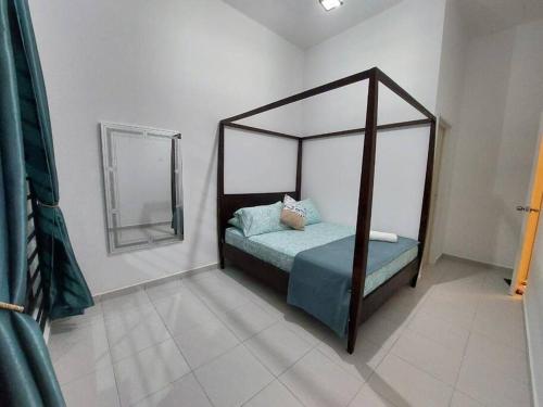 - une chambre avec un lit à baldaquin et un miroir dans l'établissement D'has Homestay Kuantan, à Kampong Baharu