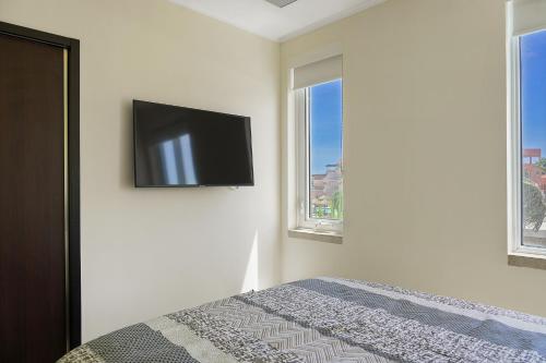 a bedroom with a bed with a flat screen tv on the wall at LUXURIOUS APARTMENT IN LEVENT FRONT EAGLE BEACH in Palm-Eagle Beach