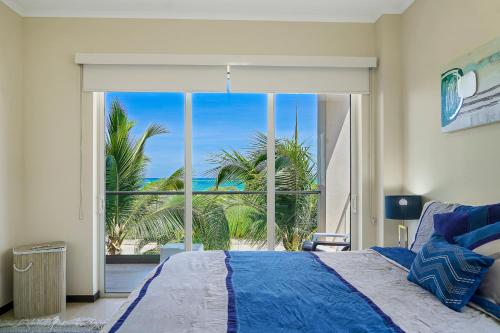 een slaapkamer met een bed en een groot raam bij LUXURIOUS APARTMENT IN LEVENT FRONT EAGLE BEACH in Palm-Eagle Beach
