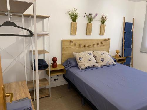 a bedroom with a bed and a shelf with flowers at Tranquilidad y confort, Apartamento reformado en Cambrils in Cambrils