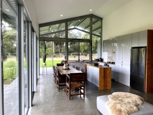 a kitchen and dining room with a table and a large window at Isle of Kilcarnup in Margaret River Town