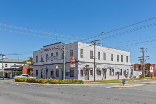 a white building on the corner of a street at Albion Motel Finley in Finley