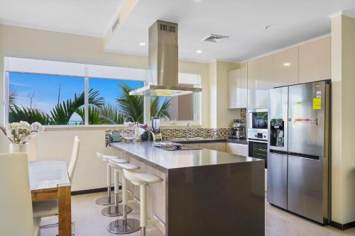 een keuken met roestvrijstalen apparatuur en een groot raam bij LUXURIOUS APARTMENT IN LEVENT FRONT EAGLE BEACH in Palm-Eagle Beach