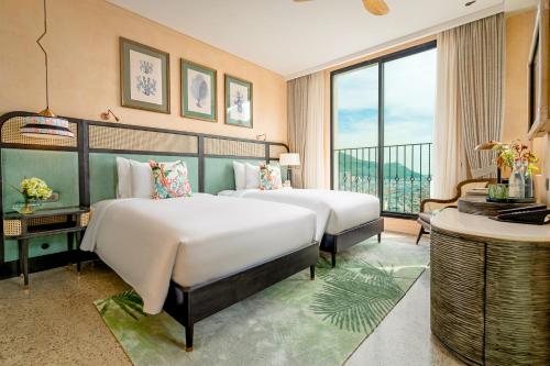 a hotel room with two beds and a balcony at L'amor Boutique Hotel Quy Nhơn in Quy Nhon