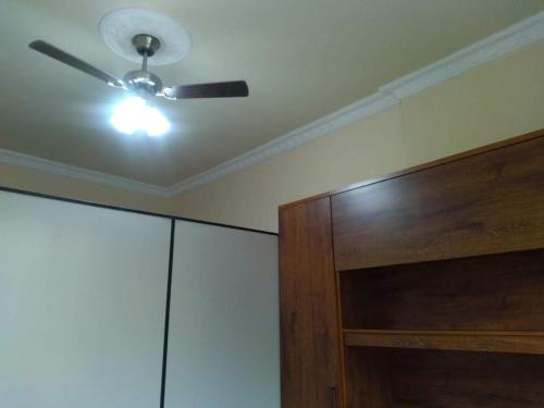 a ceiling fan and a wooden cabinet in a room at Loft Aconchegante no Centro de Niterói!! in Niterói