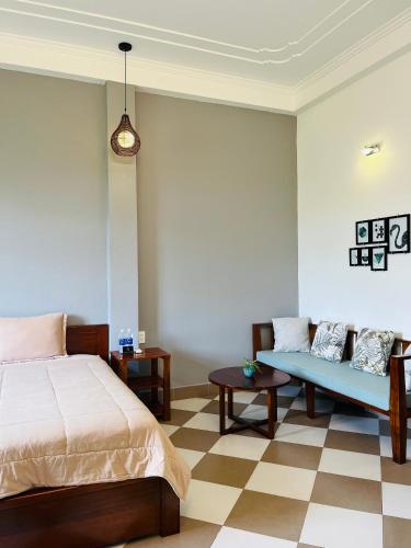 a bedroom with a bed and a couch at Queenie House in Can Tho