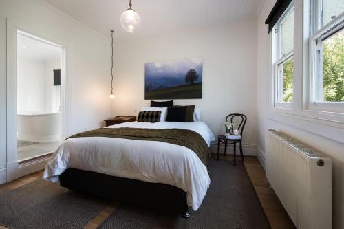 a bedroom with a bed and a large window at Annecy House in Daylesford