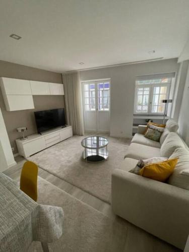 a living room with a couch and a tv at Modern 1 Bedroom City Center Aveiro Apartment in Aveiro