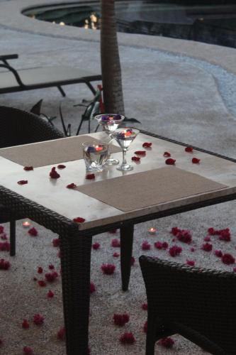 a table with wine glasses and roses on the ground at The Mayana Resort in Dauis