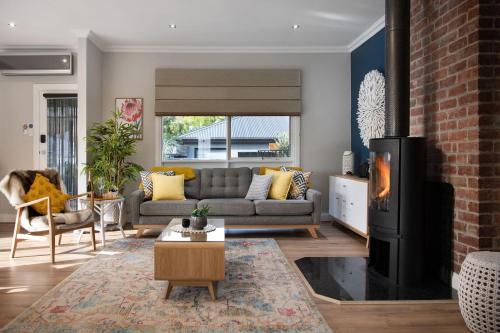 a living room with a couch and a fireplace at Arabella Heights in Daylesford
