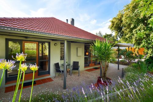 a house with a table and chairs in a garden at Arabella Heights in Daylesford