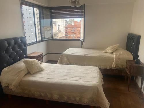 a hotel room with two beds and a window at Depto Boulevard Illia in Cordoba