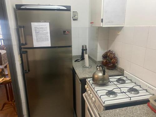 a kitchen with a stainless steel refrigerator and a stove at Depto Boulevard Illia in Cordoba