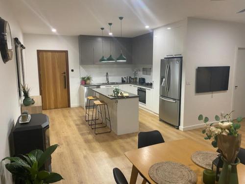 a kitchen with a refrigerator and a table and chairs at Banjo's Rest in Jindabyne