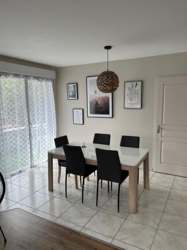 une salle à manger avec une table et des chaises dans l'établissement Charmant appartement la Roche sur Yon, à La Roche-sur-Yon