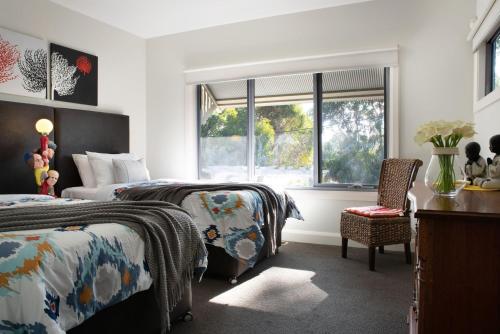 sypialnia z 2 łóżkami, krzesłem i oknem w obiekcie Arabella Meadows w mieście Daylesford